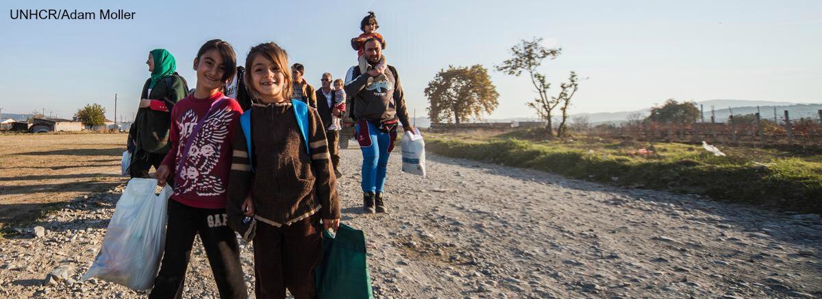The Syrian Crisis Regugees walking along gravel path